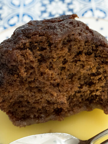 An individual Gingerbread with Orange Sauce on a white plate with dots.