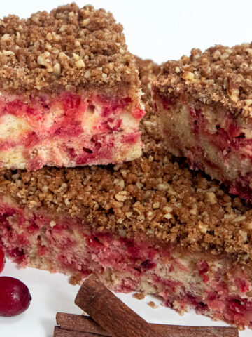 Squares of Cranberry Pecan Streusel Coffee Cake with cranberries and cinnamon sticks