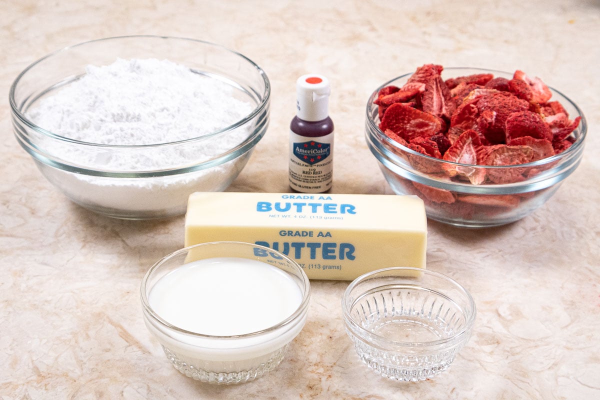 Ingredients for the Strawberry Buttercream Frosting include powdered sugar, red food coloring, freeze dried strawberries, butter, milk, and almond extract.