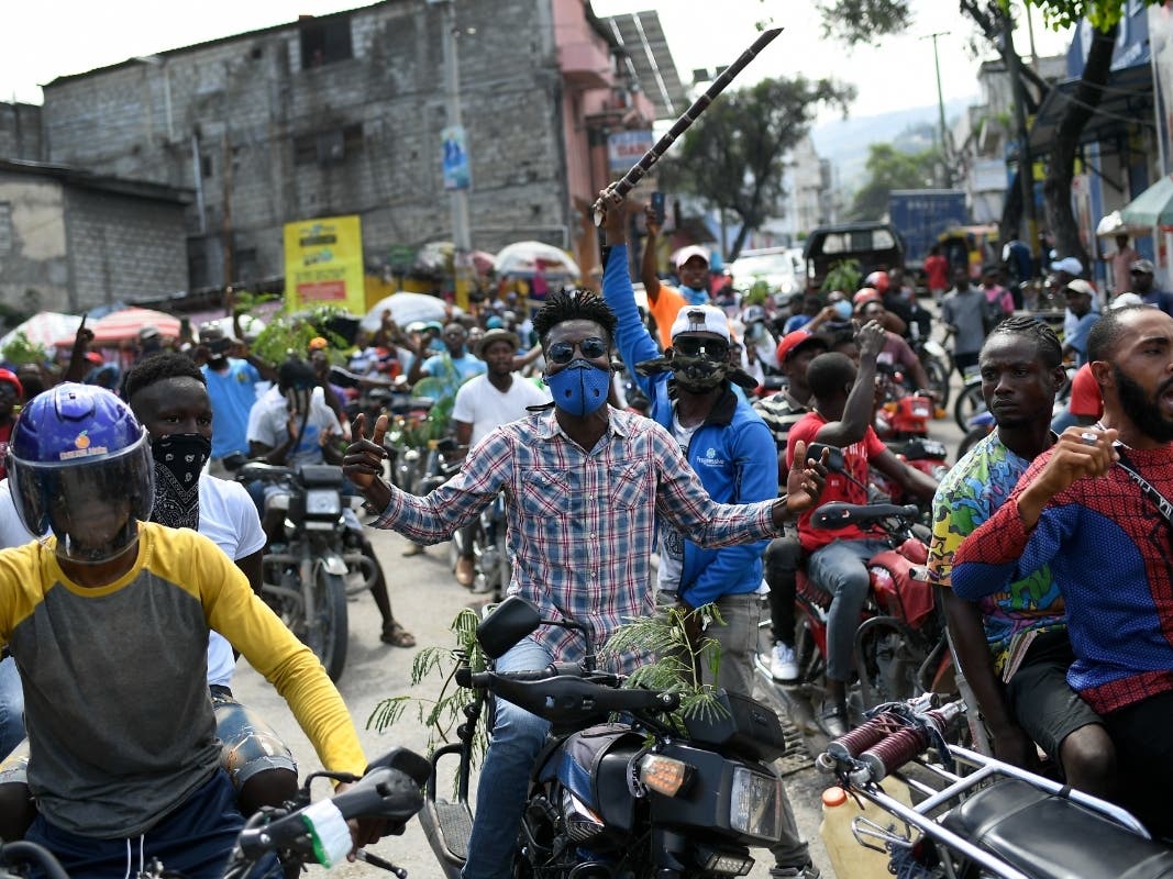 Motorcyclists unable to find gas ride in protest to the home of acting Haitian Prime Minister Ariel Henry in Port-au-Prince on Tuesday. Haiti has become increasingly lawless after the former prime minister was assassinated.
