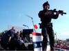 Republican presidential candidate former President Donald Trump is covered by U.S. Secret Service agents at a campaign rally as an officer stands guard.