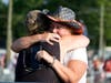 People hug after Republican presidential candidate former President Donald Trump was helped off the stage at a campaign event after an attempted assassination. 