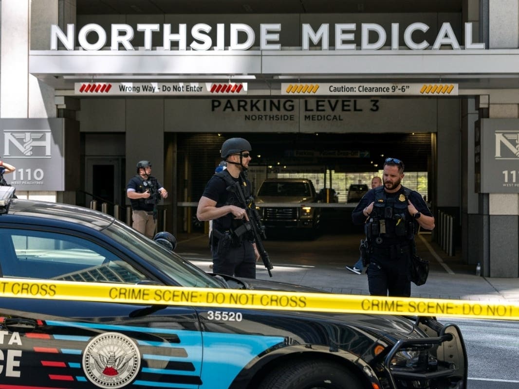 Law enforcement officers stand Northside Hospital Midtown medical office building, where five people were shot, Wednesday, May 3, 2023, in Atlanta. 