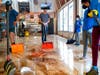 Volunteers, employees and family members remove water and mud from Goldberg's Famous Deli in Millburn, N.J., Saturday, Sept. 4.