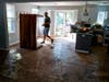 Josh Herrera salvages a table on the damaged first floor of his Millburn home Saturday. After seeing the water rapidly rise from sewer grates, Herrera with his wife and children had to escape their home by walking through waist-deep flood water.
