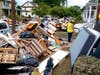 Utility workers work among debris from flood damage caused by the remnants of Hurricane Ida in Manville Sunday.