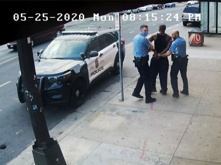 This image from video shows Minneapolis police Officers Thomas Lane (left) and J. Alexander Kueng (right) escorting George Floyd to a police vehicle outside Cup Foods in Minneapolis on May 25, 2020.