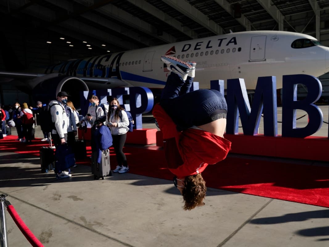 Freestyle skier Mac Forehand does a backflip as he conducts an interview before boarding a plane to Beijing for the 2022 Beijing Olympics at a Delta Airlines terminal Thursday in Los Angeles. 