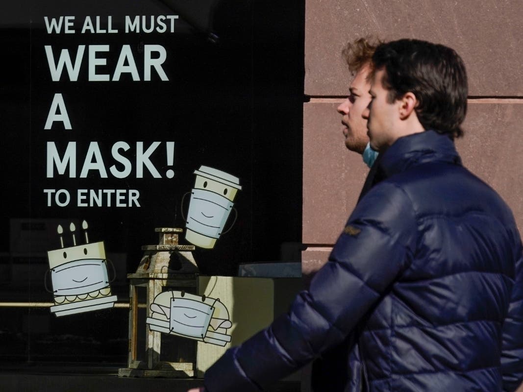 Pedestrians walk past a sign Wednesday asking patrons to wear a mask in New York. New York Gov. Kathy Hochul announced Wednesday that the state will end a COVID-19 mask mandate requiring face coverings in most indoor public settings.