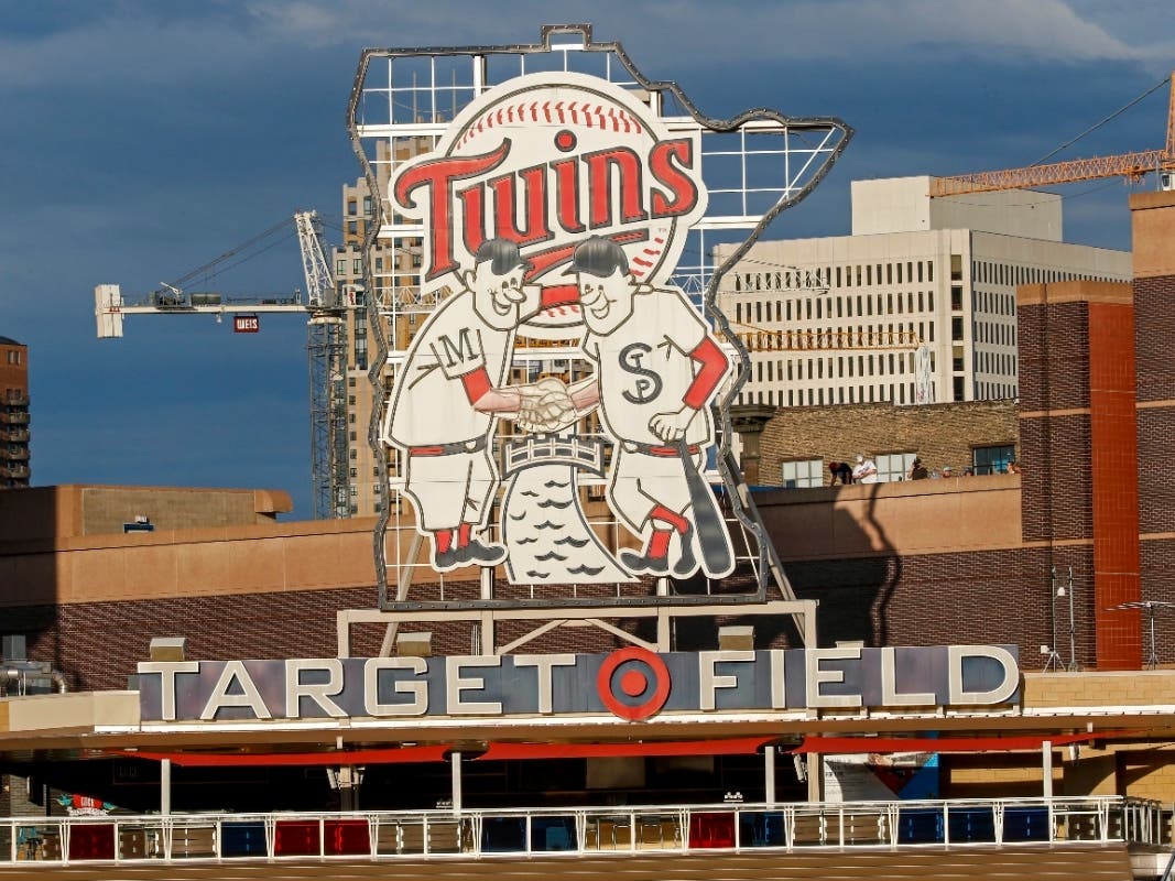 A few fans on the top of a parking garage watch the Cleveland Indians play the Minnesota Twins in a baseball game Saturday, Aug. 1, 2020, in Minneapolis.