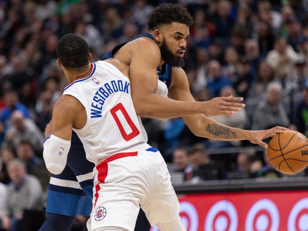 Minnesota Timberwolves center Karl-Anthony Towns, right, works toward the basket while Los Angeles Clippers guard Russell Westbrook (0) defends during the second half of an NBA basketball game Sunday, Jan. 14, 2024, in Minneapolis.