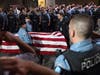 Law enforcement officers salute the flag-draped remains of fallen Minneapolis police Officer Jamal Mitchell as he is escorted to a waiting medical examiner's vehicle outside Hennepin County Medical Center in Minneapolis, Thursday, May 30, 2024. 