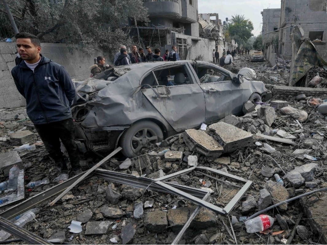 Palestinians inspect the rubble of a building of the Al Nawasrah family destroyed in an Israeli strike in Maghazi refugee camp, central Gaza Strip, Monday, Dec. 25, 2023.