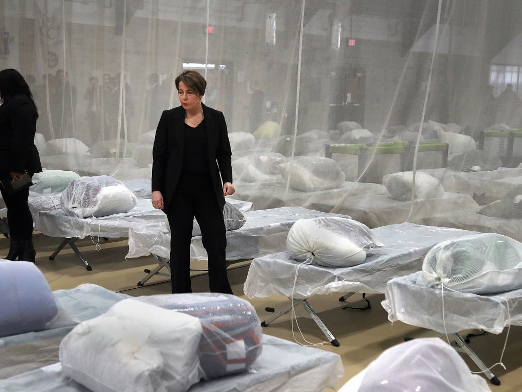 Gov. Maura Healey pauses to look at the Army cots set up on the gym floor during a tour of the 300-bed respite shelter at the Melnea A. Cass Recreational Complex in January.