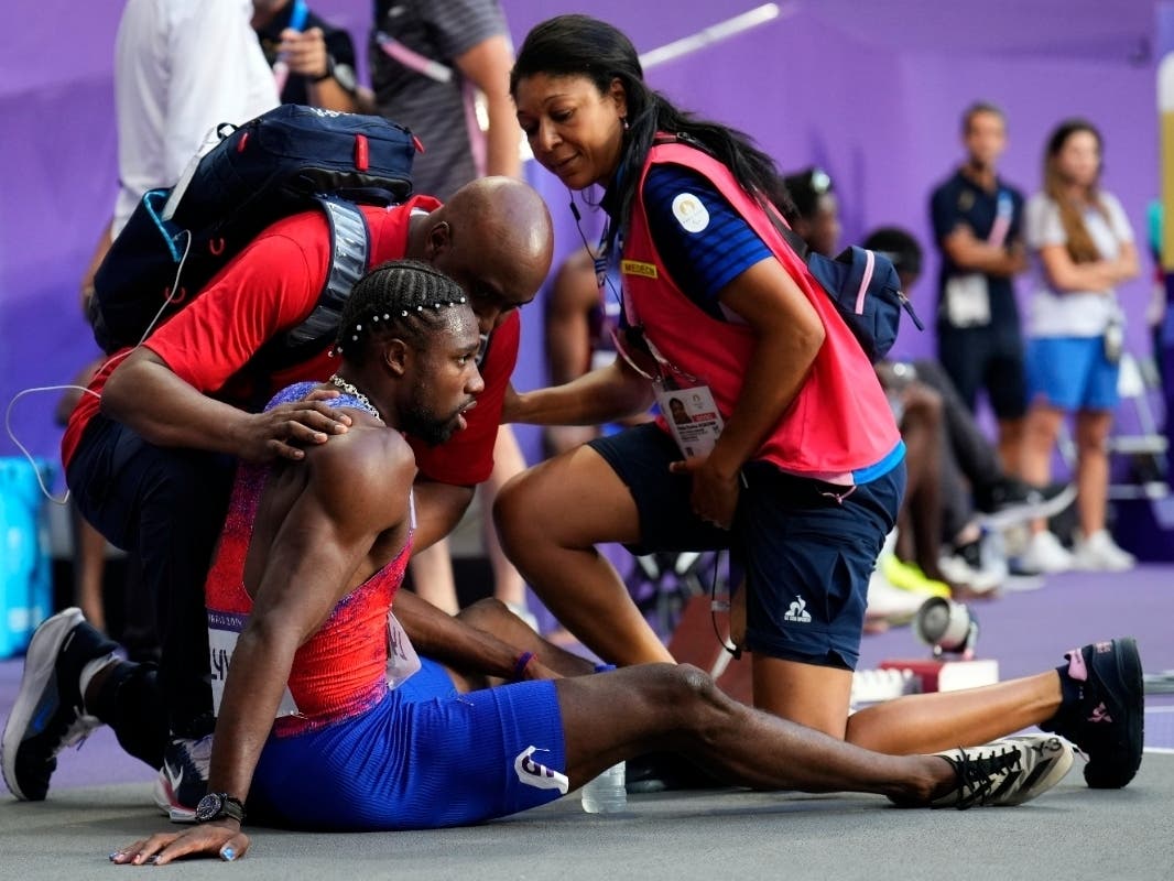 Noah Lyles is treated by medical staff following the men's 200M event, where he won the bronze medal. Lyles was diagnosed with COVID two days ago.