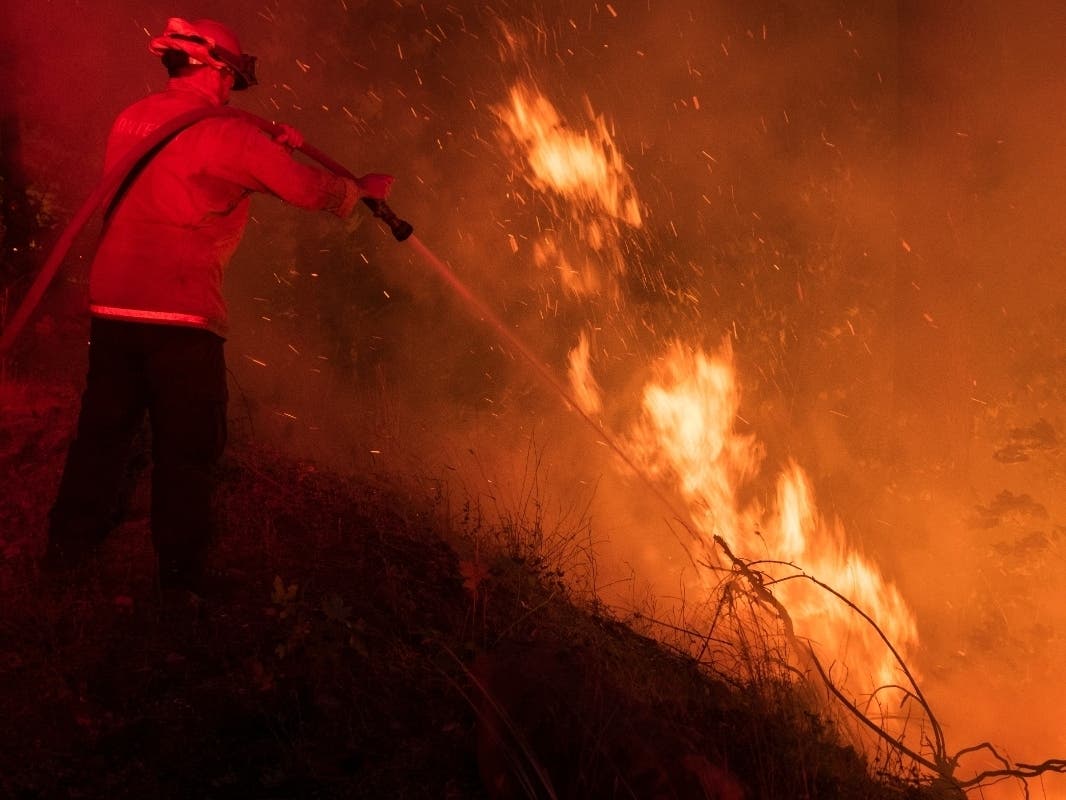 A firefighter from the city of Monterey sprays water on flareups from the Park Fire near Butte Meadows, Calif., Sunday, July 28, 2024.