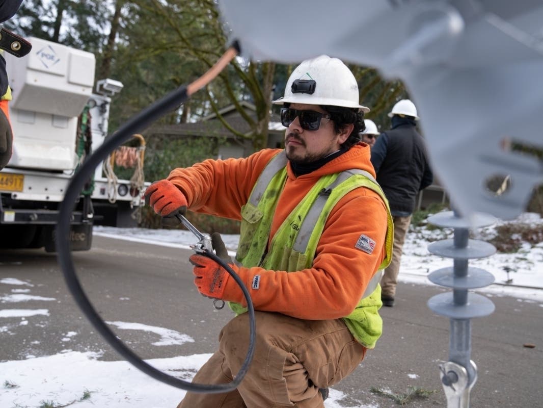 ​A worker from Portland General Electric replaces a power line as crews work to restore power after a storm on Jan. 16, 2024, in Lake Oswego, Oregon. The unemployment rate remained low in Janaury at 3.7 percent, just above a half-century low.