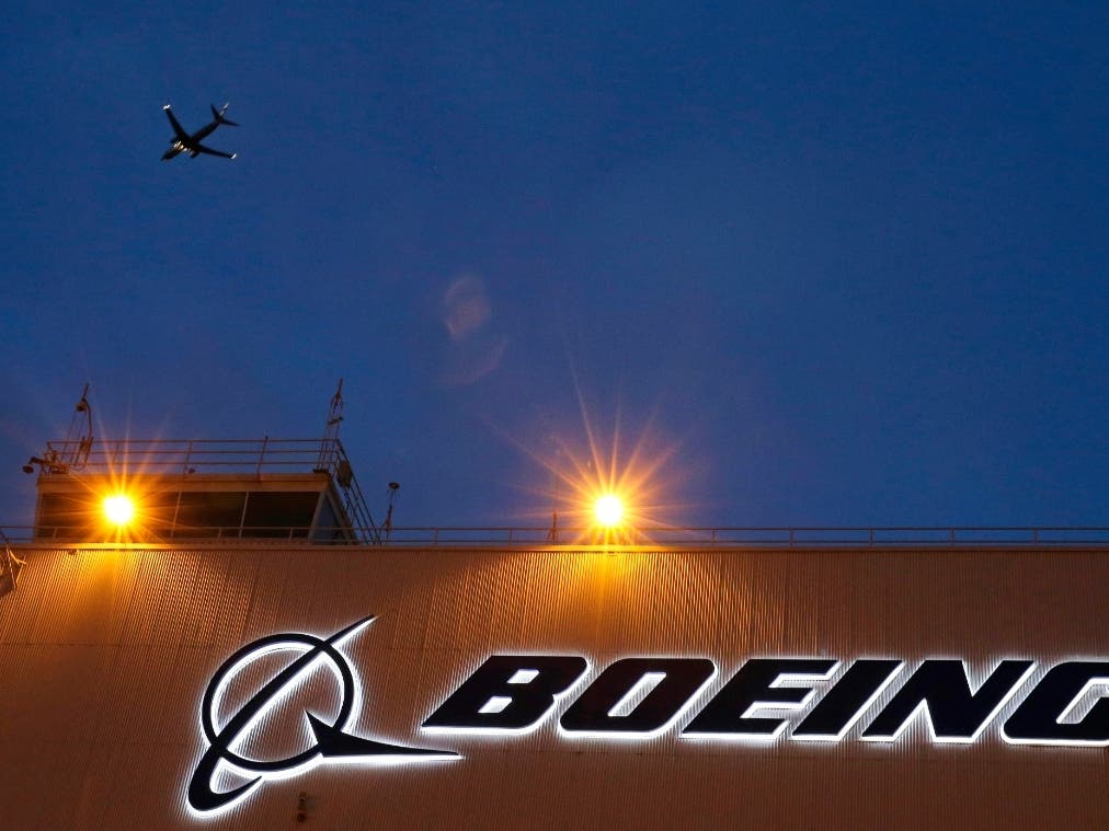 FILE - An airplane flies over a sign on Boeing's 737 delivery center, Oct. 19, 2015, at Boeing Field in Seattle.