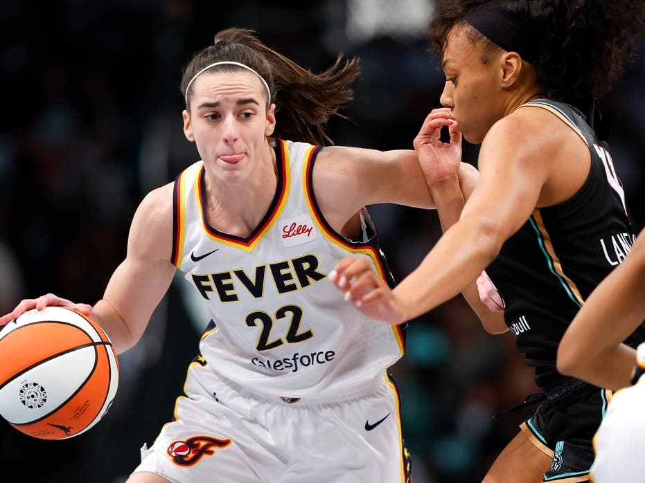 Indiana Fever guard Caitlin Clark (22) drives to the basket against New York Liberty forward Betnijah Laney-Hamilton (44) during the first half of a WNBA basketball game