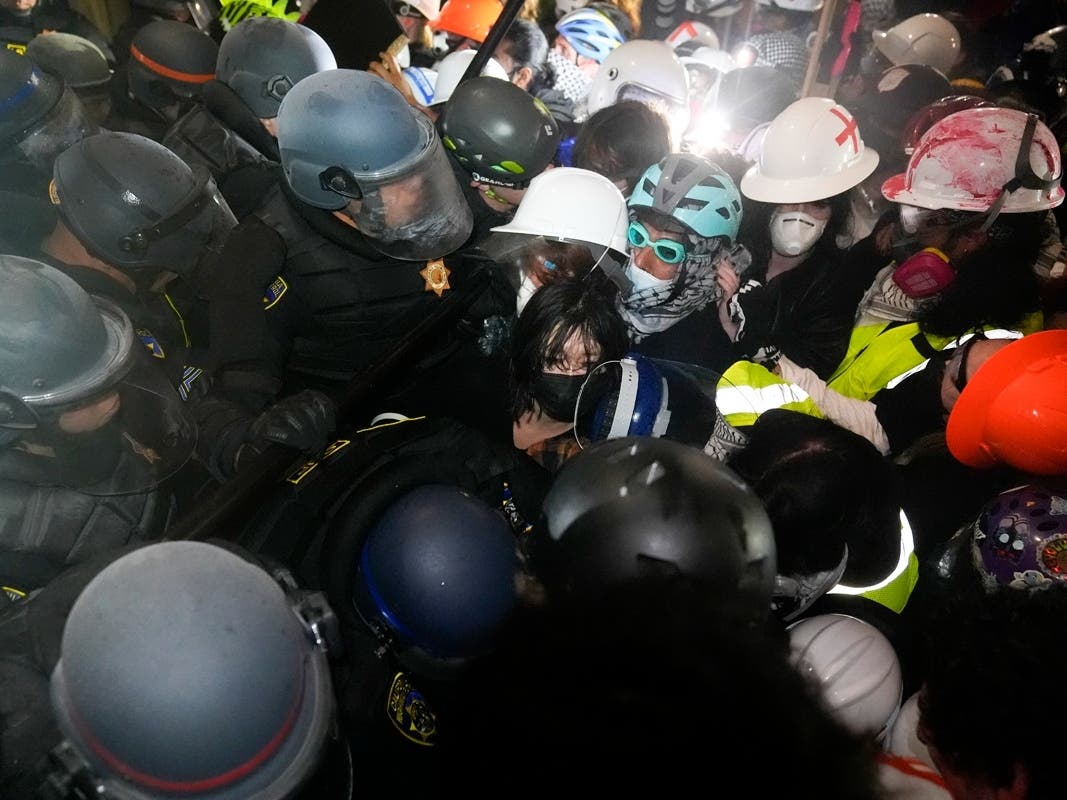 Police face off with pro-Palestinian demonstrators inside an encampment on the UCLA campus Thursday, May 2, 2024, in Los Angeles. 