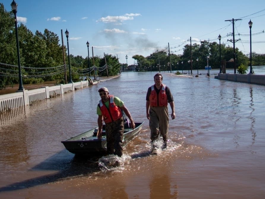 United States Geological Survey workers push a boat as they look for residents on a flooded street along the Raritan River in Somerville, N.J.., Thursday, Sept. 2.