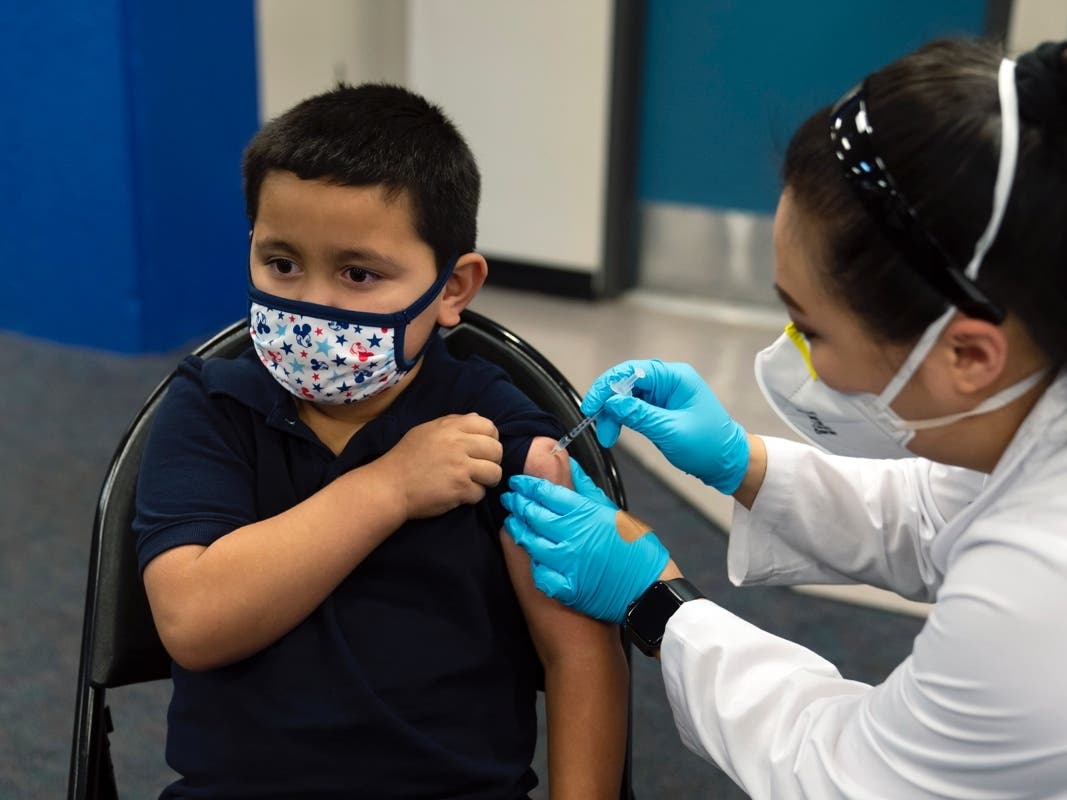 Six-year-old Eric Aviles receives the Pfizer COVID-19 vaccine from pharmacist Sylvia Uong at a pediatric vaccine clinic for children ages 5 to 11 set up at Willard Intermediate School in Santa Ana, Calif.