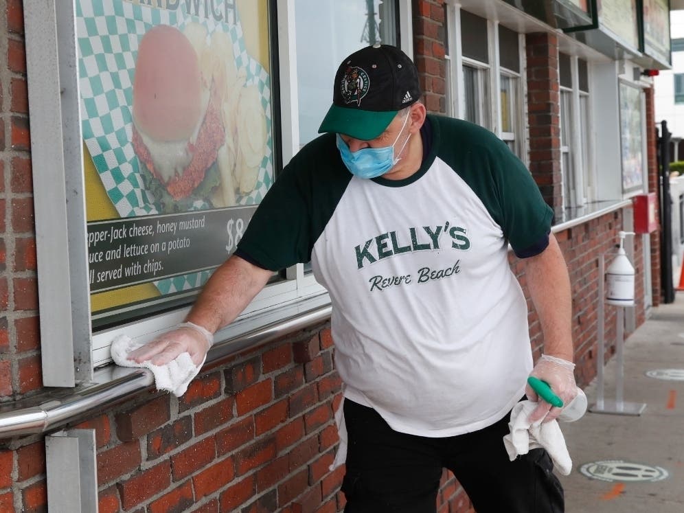 Chris Dotoli wipes down surfaces, Wednesday, June 3, 2020, outside Kelly's Roast Beef in Revere, Mass. Kelly's is open for outside delivery of food in accordance with the state's coronavirus guidelines. 