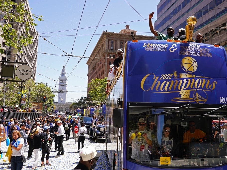 Stephen Curry and Damion Lee (right) ride atop a bus during the Golden State Warriors' NBA championship parade in San Francisco on Monday.