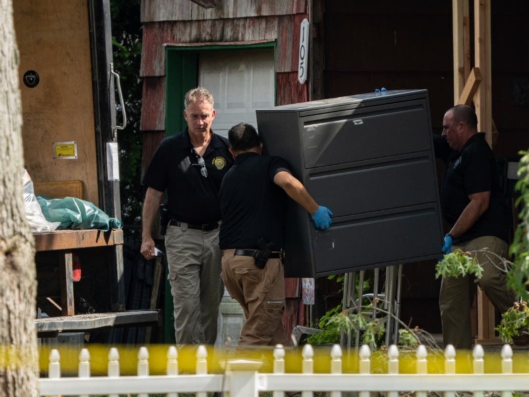 New York State police officers move a metal cabinet as law enforcement searches the home of suspected serial killer Rex Heuermann, Saturday, July 15, 2023, in Massapequa Park. 