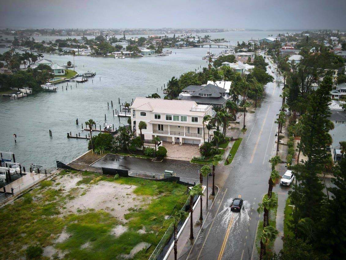 A driver negotiates a flooded street as Tropical Storm Debby passes just to the west of the Tampa Bay, Fla., region, Sunday, Aug. 4, 2024.