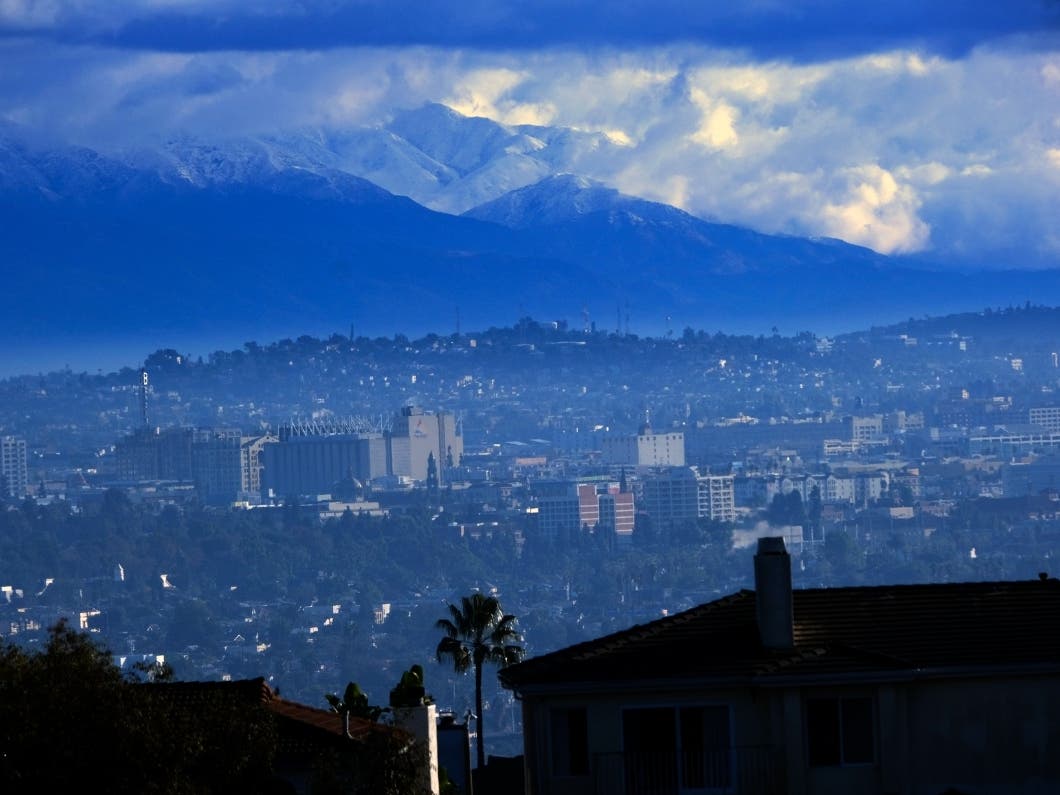 Heavy storm clouds and snow are seen in the San Gabriel mountain range behind an area of downtown Los Angeles. California is drenched or blanketed as a series of storms hit (file). 