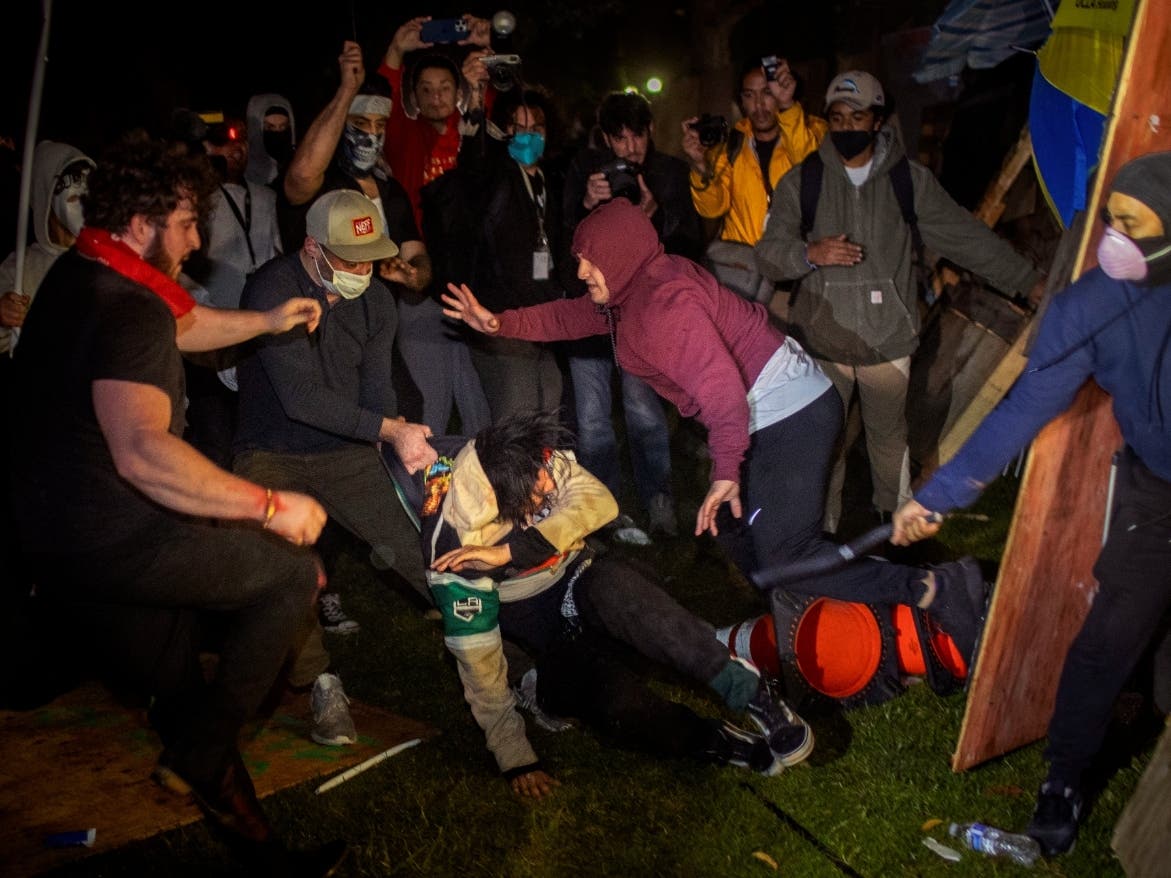 Demonstrators clash at an encampment at UCLA early Wednesday in Los Angeles. Dueling groups of protesters have clashed at the UCLA grappling in fistfights and shoving, kicking and using sticks to beat one another. 