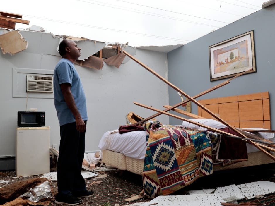 With the roof blown off by severe winds, Brian Patel, owner of the Skyline Motel in the suburban town of McCook, for the past 30 years, surveys storm damage in one of the motel rooms.