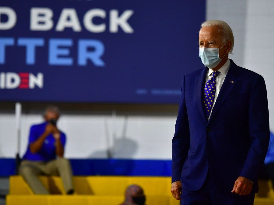 Presidential candidate Joe Biden wears a mask before going on stage for a political address.