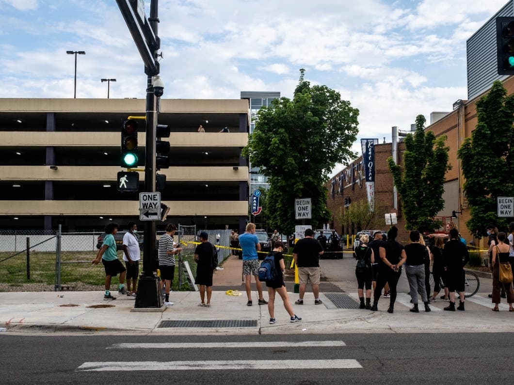 People gather outside a scene where a person was killed during an arrest attempt on June 3, 2021 in Minneapolis, Minnesota. Members of a U.S. Marshals Service task force were attempting to arrest the man in a parking ramp when the shooting occurred. 