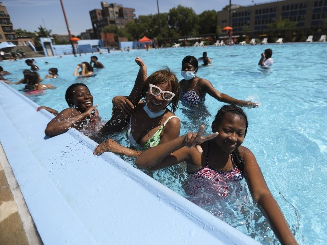 People enjoy themselves in a swimming pool in New York on July 27, 2020.