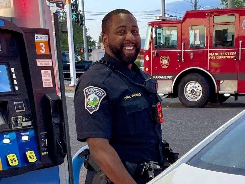 Manchester police officer Garrett Thomas was all smiles as he pumped gas for a man who fell at a local station Tuesday. 