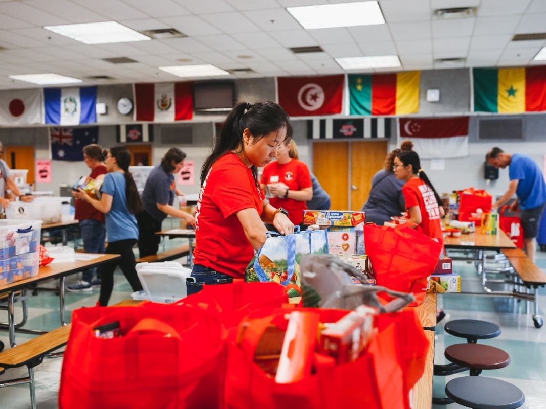 Community members gather at Whitman Middle School to receive and sort food and toiletries for delivery to six local schools.