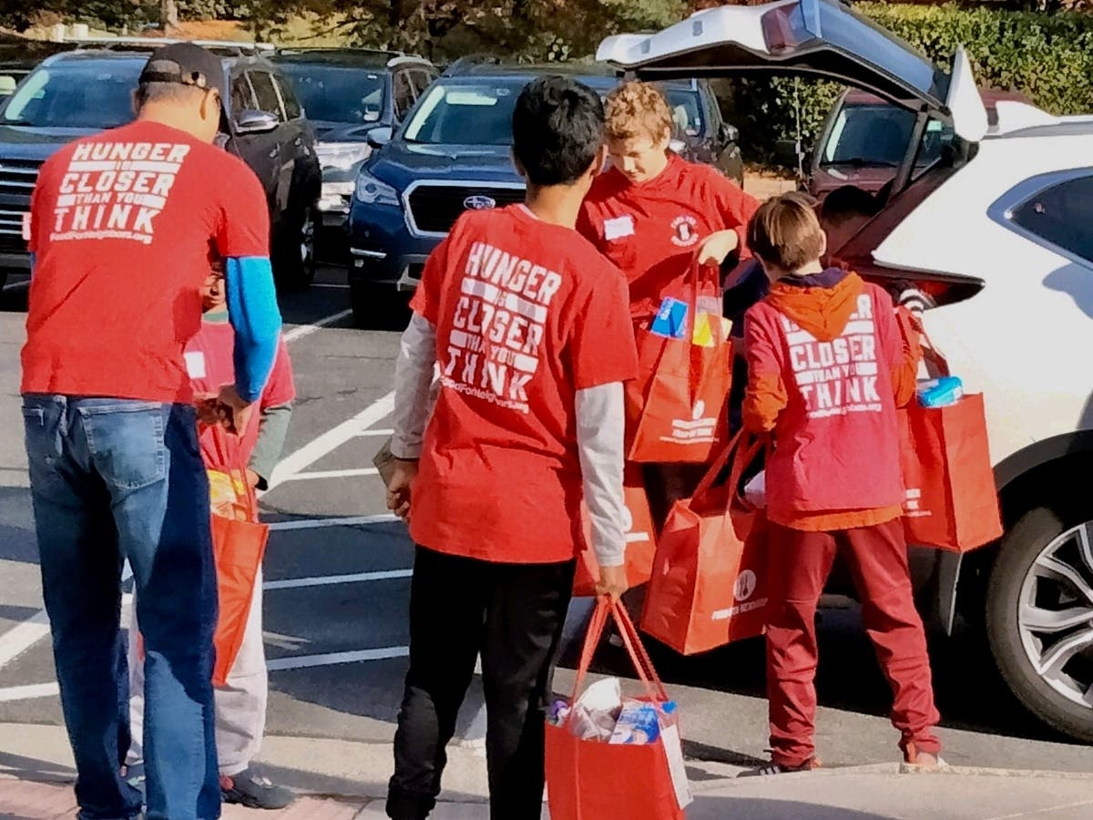 Volunteers of all ages unload car after car of food and toiletries donated by 131 Ashburn area households. In all, community volunteers collected and sorted 1,684 pounds of donations to support students in partnering local schools.