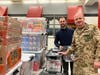 Commander Dirk Miesler (right) helps stack heavy bins filled with food and toiletry donations for local students in need. Throughout its Northern Virginia service area, Food For Neighbors collected and sorted over 26,500 pounds of donations.