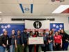 Sherry Hwang (7th from left), Co-founder of Pyramid Systems, with Pyramid Cares Committee Representative Terra Lee (5th from left) and additional team members, presents a $2,500 check to Food For Neighbors. 