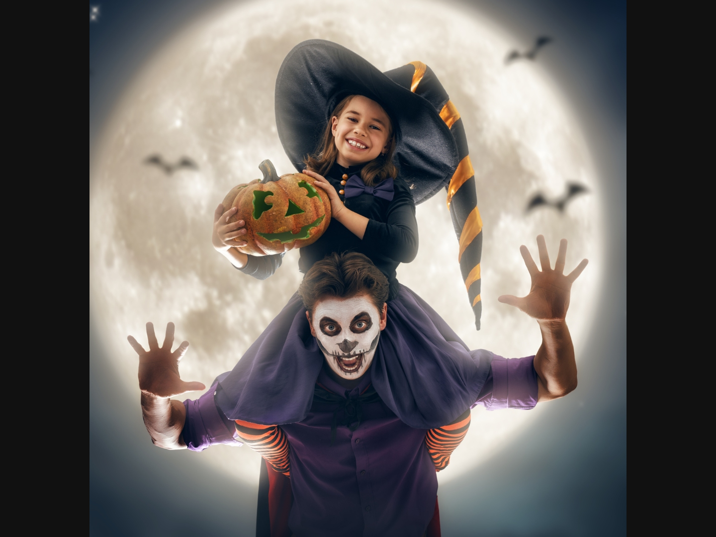 A child dressed in a Halloween costume is sitting on the shoulders of an adult dressed in a Halloween costume.  
