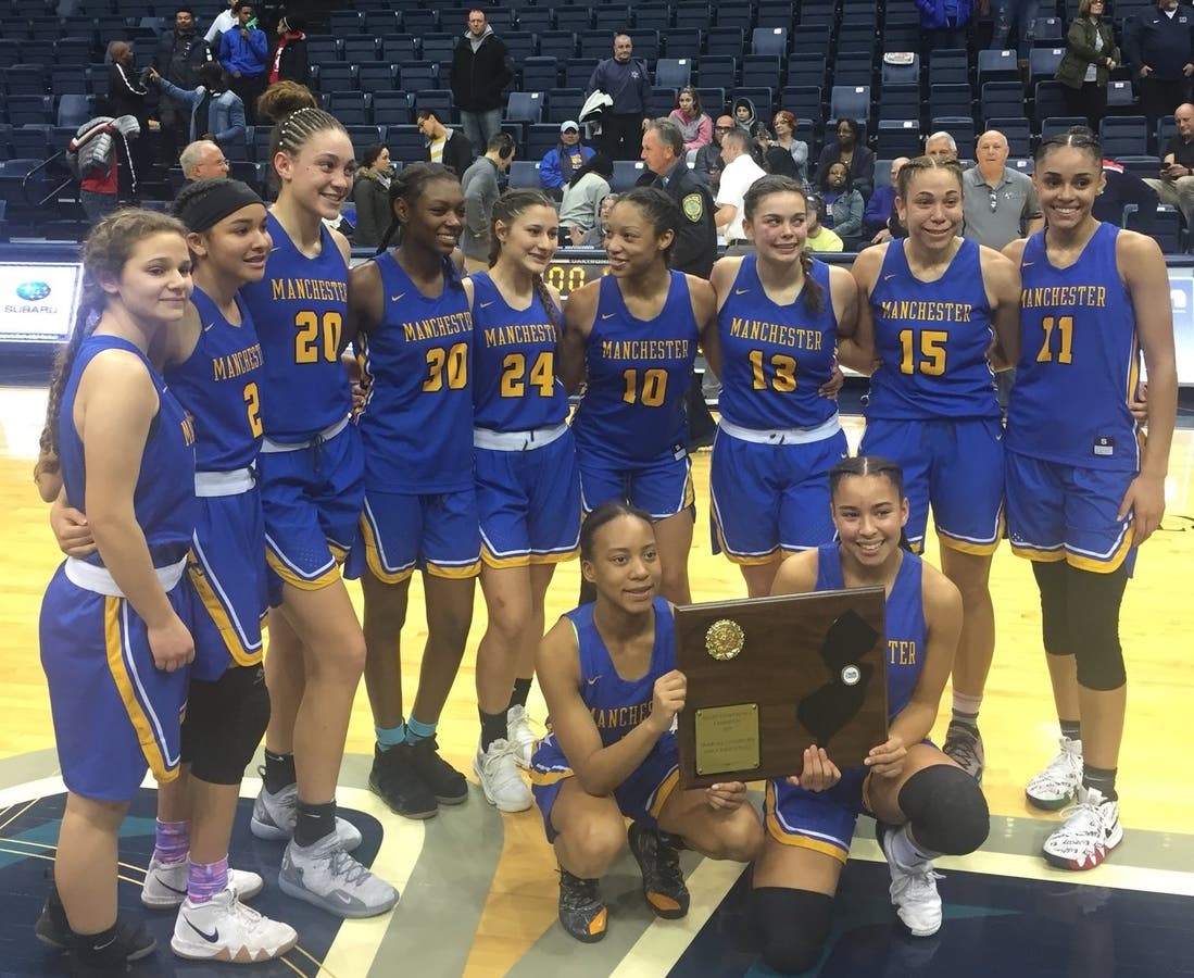 The Manchester Township Hawks girls basketball team shows off its Shore Conference Tournament trophy. 