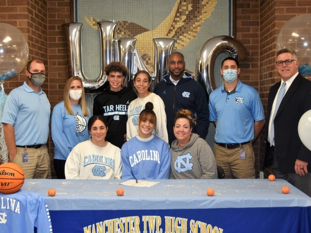 Manchester's Destiny Adams is surrounded by her family and coaches as she signs her national letter of intent to attend the University of North Carolina.