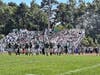 Baby powder drifts in the breeze as the Brick Township student section celebrates a positive play by the Dragons. 