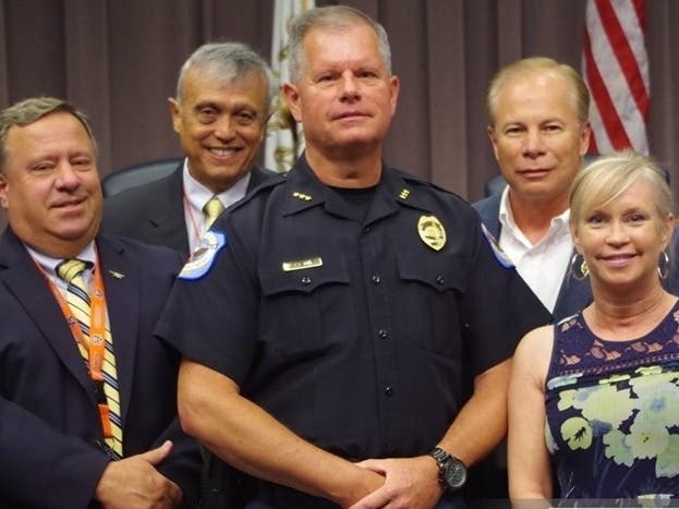 Family members surround Police Chief Tim Cox at Tuesday's ceremony.