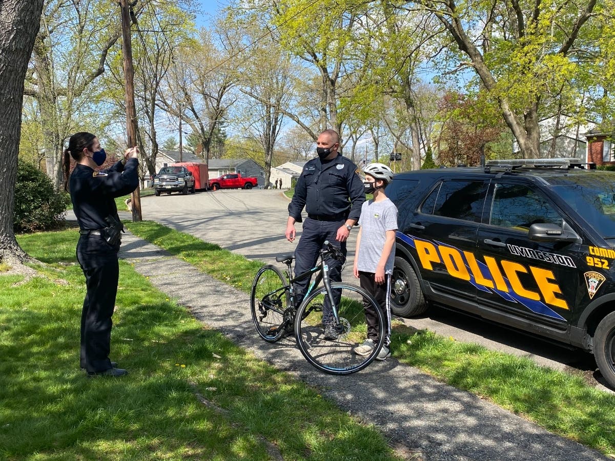 Livingston police officers Joy Klapal and Ralph Kolbusz pose with Taylor Altomare while filming a segment on wearing a properly-fitted helmet.