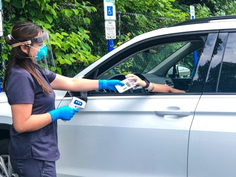 VNA Certified Medical Assistant Ali Robles provides a COVID-19 test kit to a local resident at the Red Bank Family YMCA, now a site for testing three days a week by the Visiting Nurse Association of Central Jersey Community Health Center.