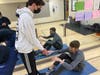 North Suburban YMCA Exercise Connection volunteer Zack Lofman (left) helps Exercise Connection participant do sit-ups.