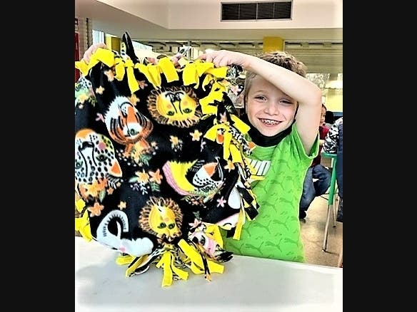 Evan Rosenburg proudly displays the blanket he made last year at the North Suburban YMCA’s Pet Blanket Making event. This year’s event will take place on February 19.